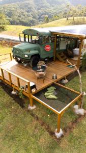 a green bus parked on a wooden deck at D'Alma Bus com café da manhã in Pomerode