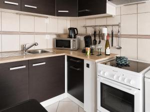 a kitchen with a sink and a stove top oven at Le Cocon appart avec parking privé & terrasse in Sainte-Croix-en-Plaine