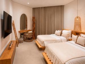 a hotel room with two beds and a television at Umm Al Quwain Beach Hotel in Umm Al Quwain +55 photos