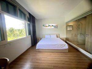 a bedroom with a bed and a shower and a window at Emerald Marina TL in Phú Quốc +29 photos