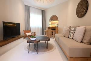 a living room with a couch and a tv at Umm Al Quwain Beach Hotel in Umm Al Quwain