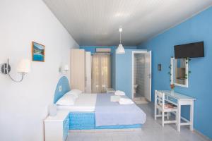 a blue room with a bed and a television at Blue White House in Kalamitsi