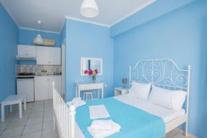 a blue bedroom with a bed and a kitchen at Blue White House in Kalamitsi