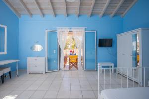 a blue room with a door open to a patio at Blue White House in Kalamitsi