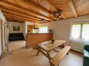 a living room with a wooden ceiling and a table at Gîte Arnica in Soultzeren