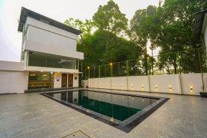 a swimming pool in front of a building at Tiger Hill Hotel & Suites in Kalpetta