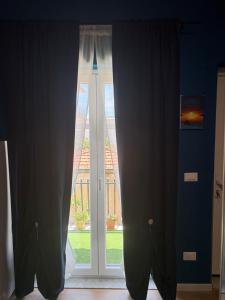 a window with curtains in front of a door at Sciuri House in CTA