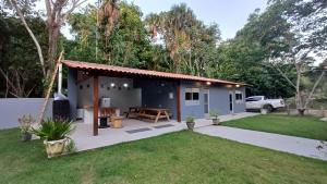a small house with a picnic table in a yard at Portobello Suítes GREEN in Santarém