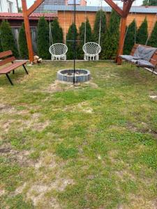a yard with two benches and a swing at LUX HOUSE Roztocze 1 in Krasnobród