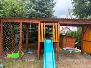 a play house with a slide and a playground at LUX HOUSE Roztocze 1 in Krasnobród +1 photo