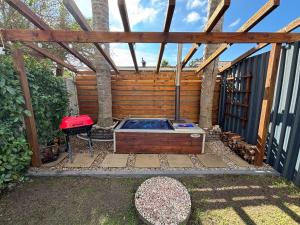 a hot tub sitting under a wooden pergola at Urban Nest Self Catering in George
