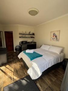 a bedroom with a large bed and a kitchen at Urban Nest Self Catering in George