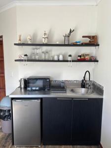 a kitchen with a sink and a microwave at Urban Nest Self Catering in George