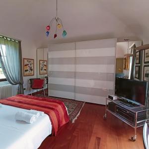 a bedroom with a bed and a flat screen tv at La Canonica della Merella B&B in Novi Ligure