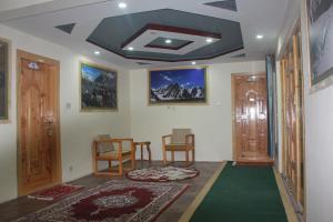 a living room with a table and chairs and a ceiling at cloudrestskardu in Skardu