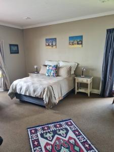 a bedroom with a bed with two rugs in it at The Blue Swallow in Kaapsehoop
