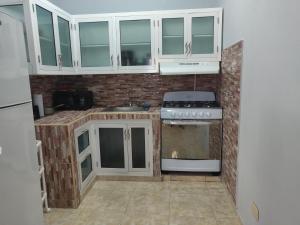 a kitchen with white cabinets and a stove at casa Verano in Cabarete