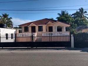 a pink house with a white fence at casa Verano in Cabarete
