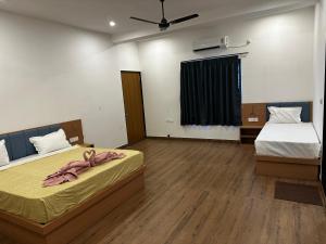 a bedroom with two beds and a ceiling fan at Hotel RK Palace in Sehot