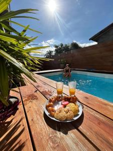 a plate of food on a table next to a swimming pool at La Villa Day **** in Les Cocos