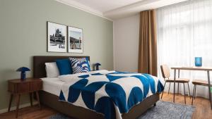 a bedroom with a bed and a table and a window at Limehome Basel Town Hall in Basel