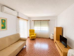 a living room with a couch and a yellow chair at Maripatri Solo Familias Serviplaya!!! in Playa de Xeraco