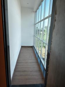 a hallway with a window and a wooden floor at Hotel RK Palace in Sehot