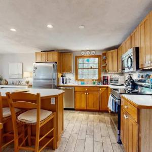 a large kitchen with wooden cabinets and a counter top at Bay Pointe Bungalow in East Falmouth