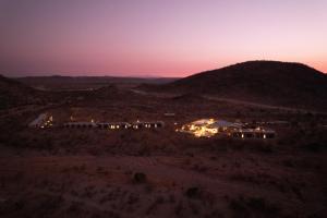 a group of houses in the desert at night at Lodge Damaraland in Khorixas