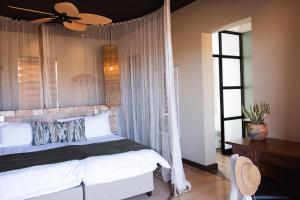 a bedroom with a bed and a ceiling fan at Lodge Damaraland in Khorixas
