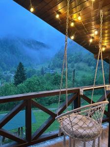 a swing on a porch with a view at Котедж Ксенія in Dzembronya +58 photos