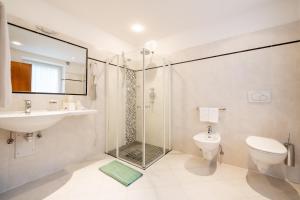 a bathroom with a shower and a toilet and a sink at Residence Frea in Selva di Val Gardena +12 photos