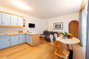 a kitchen and living room with a table and a couch at Residence Frea in Selva di Val Gardena