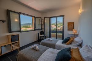 a hotel room with two beds and a window at Résidence Guddelmoni, Piscines chauffées in Propriano +124 photos
