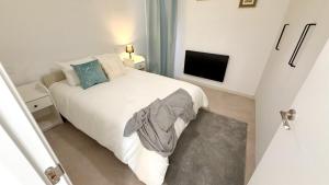 a white bedroom with a bed and a television at Posada de María Casa Cori 5 in Talavera de la Reina +2 photos