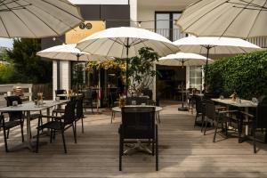 a restaurant with tables and chairs with umbrellas at B&B Armalot by Julia in De Panne