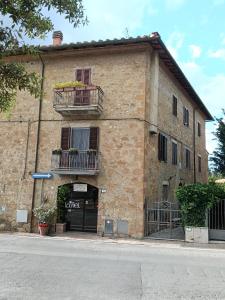 a brick building with a door and a balcony at La terrazza del Papa in Pienza