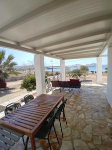 a wooden table and chairs on a patio at Aktaea, Seaside Residence in Santa Maria