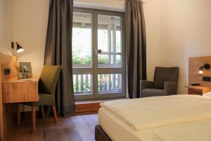 a hotel room with a bed and a desk and a window at Schloss Hohenkammer in Hohenkammer +55 photos