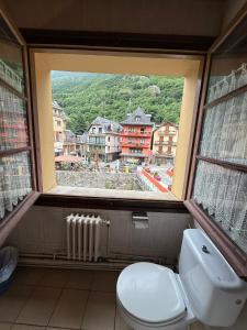 a bathroom with a toilet and a large window at Hotel Europa Les by Dynamic Hotels in Les