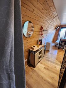 an attic room with a desk and a mirror at L'éco-maison tout confort in Puisserguier