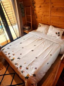 a large bed in a room with a window at L'éco-maison tout confort in Puisserguier