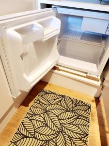 an empty refrigerator with its door open and a rug inside at L'éco-maison tout confort in Puisserguier +15 photos