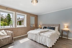 a bedroom with a large bed and two windows at Hus i Stryn med utsikt in Stryn