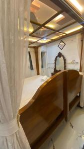 a bedroom with a wooden bed with a curtain at Vihari Luxury Resort in Alamanda +5 photos