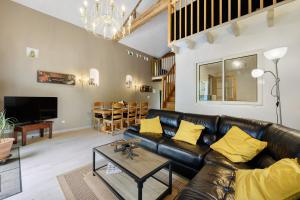 a living room with a leather couch and a table at Gîtes Du Logis De Bourseguin in Bourneau