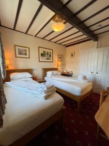 a room with two beds and a ceiling at Oakwood Bed and Breakfast Heathrow in Hillingdon