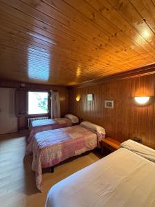 a room with three beds in a wooden cabin at Hotel Europa Les by Dynamic Hotels in Les +41 photos