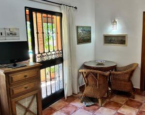 a dining room with a table and a television and a window at Cortijo Zalamea in Zalamea la Real