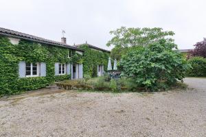 an ivy covered house with a gravel driveway at Gîtes Du Logis De Bourseguin in Bourneau